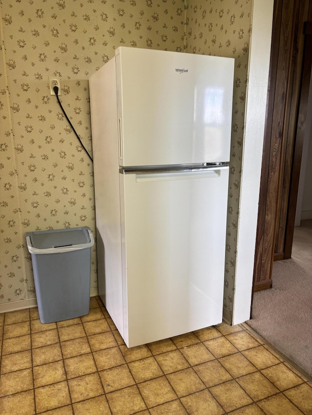 kitchen featuring freestanding refrigerator and wallpapered walls