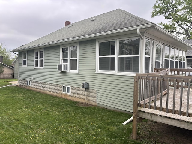 view of side of property featuring a chimney, a yard, a sunroom, a wooden deck, and roof with shingles