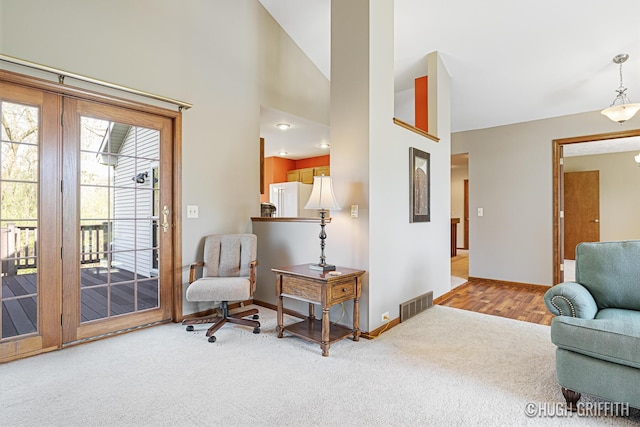 living area with carpet flooring, baseboards, a high ceiling, and visible vents