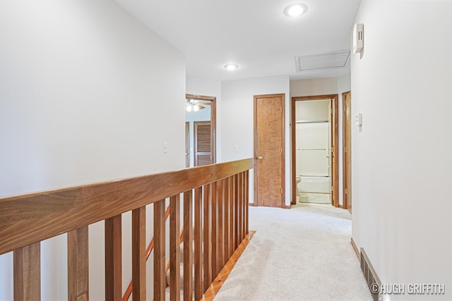 hall featuring light colored carpet, attic access, visible vents, and recessed lighting