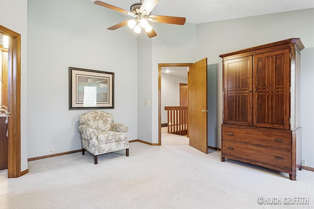 living area featuring light colored carpet, vaulted ceiling, baseboards, and a ceiling fan