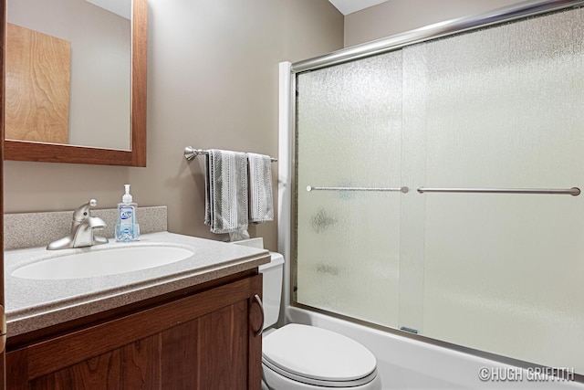bathroom with vanity, toilet, and enclosed tub / shower combo