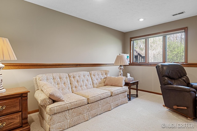 carpeted living room with a textured ceiling, baseboards, visible vents, and recessed lighting