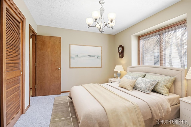 carpeted bedroom featuring an inviting chandelier and baseboards