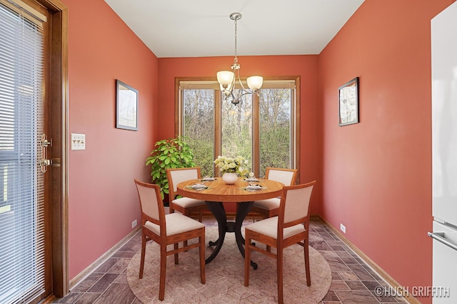 dining room with baseboards and an inviting chandelier