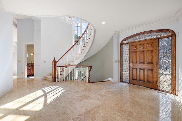 entrance foyer with marble finish floor, baseboards, ornamental molding, and stairs