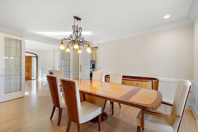 dining room featuring ornamental molding and light wood finished floors