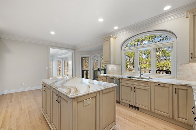 kitchen featuring backsplash, a healthy amount of sunlight, a sink, and a kitchen island