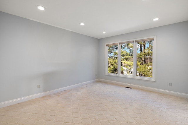spare room featuring light tile patterned floors, baseboards, and recessed lighting