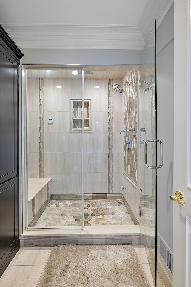 bathroom with a stall shower, ornamental molding, and visible vents