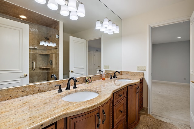 bathroom featuring a sink, double vanity, baseboards, and tiled shower