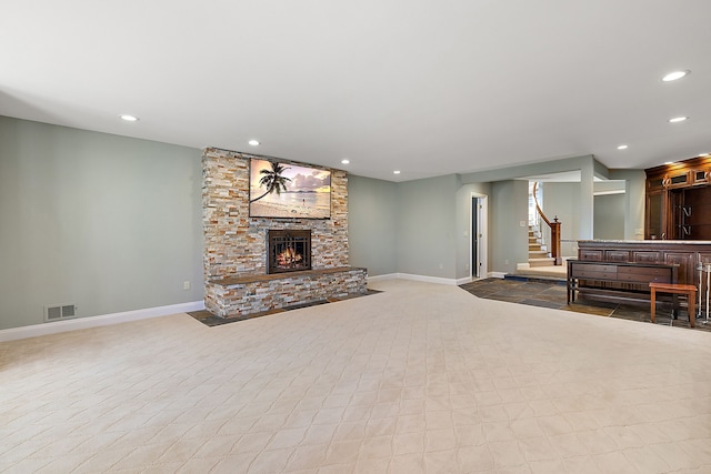 living room with a large fireplace, stairs, visible vents, and recessed lighting