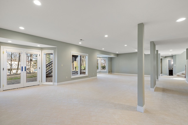 below grade area featuring light colored carpet, french doors, baseboards, and recessed lighting