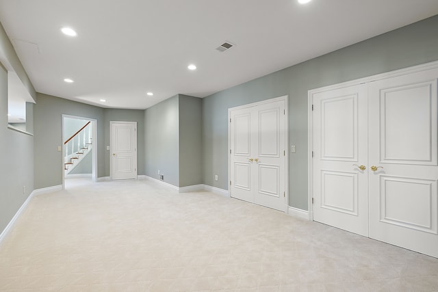 basement featuring stairs, baseboards, and recessed lighting