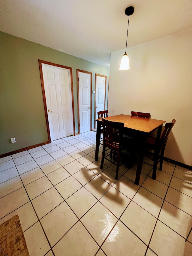 dining space featuring light tile patterned floors and baseboards