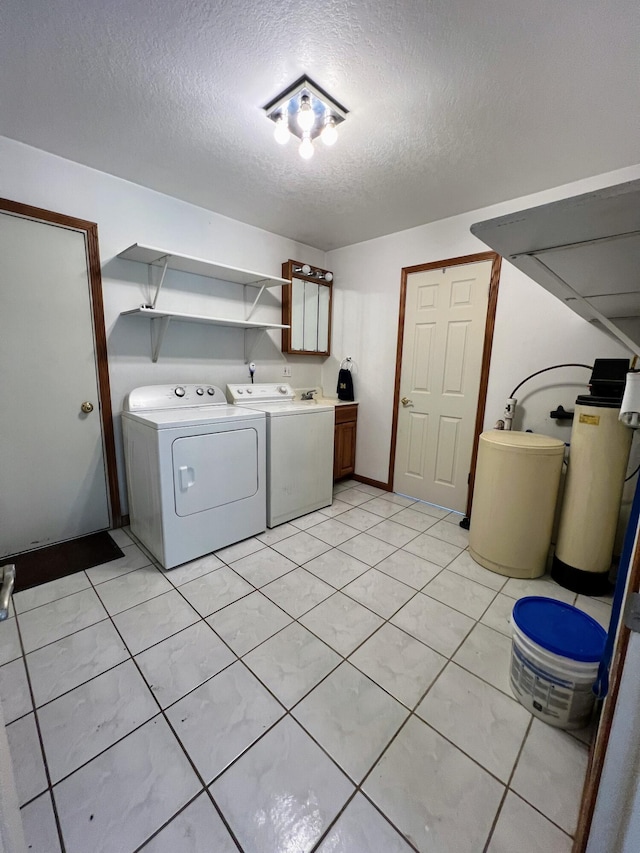 clothes washing area featuring a textured ceiling, cabinet space, and independent washer and dryer