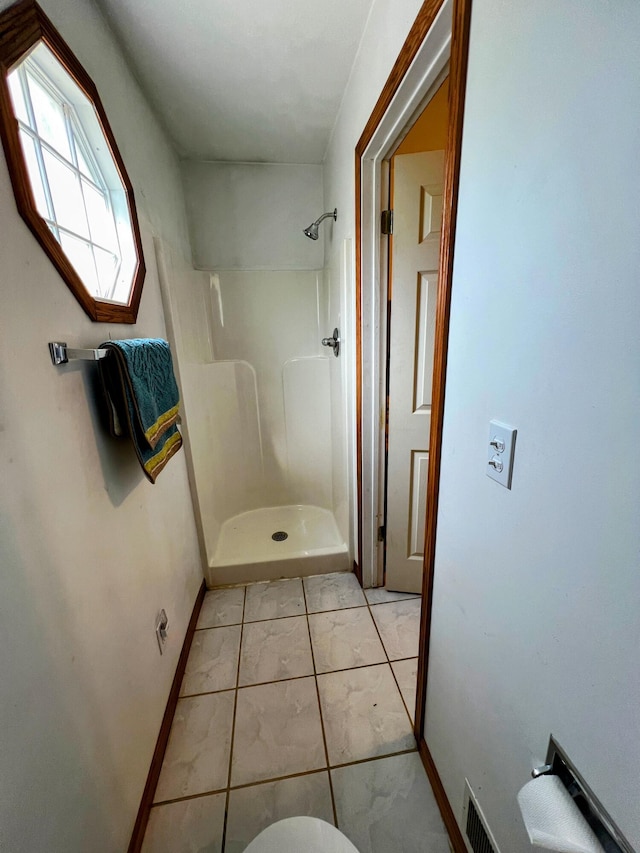 bathroom with baseboards and a stall shower