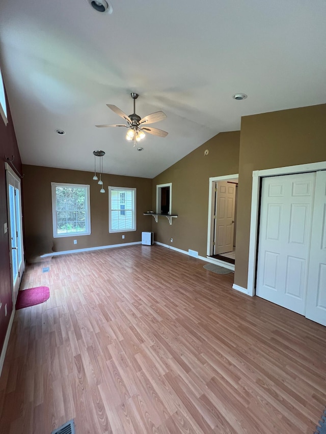 unfurnished living room featuring lofted ceiling, baseboards, light wood finished floors, and ceiling fan