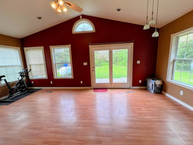 interior space with vaulted ceiling, baseboards, a ceiling fan, and wood finished floors