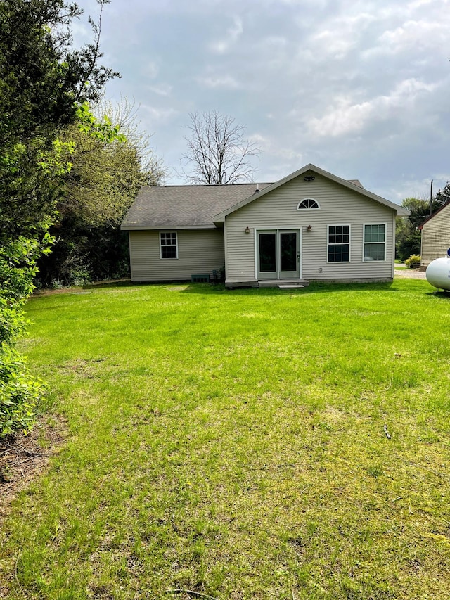 rear view of house featuring a lawn