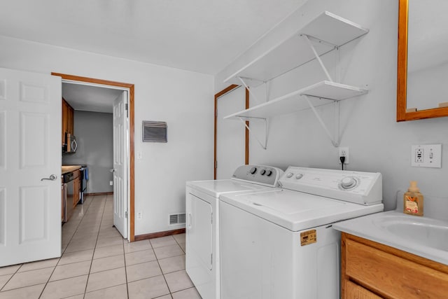 12938 Kelley Rd, Brooklyn, MI 49230 - clothes washing area featuring washer and dryer, light tile patterned floors, and baseboards
