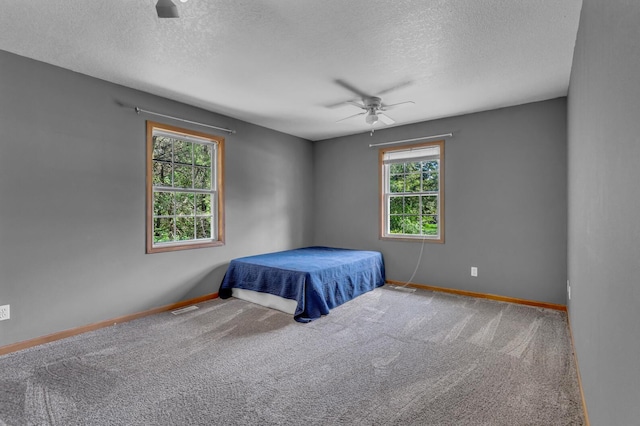 12938 Kelley Rd, Brooklyn, MI 49230 - carpeted bedroom featuring a textured ceiling, baseboards, and a ceiling fan