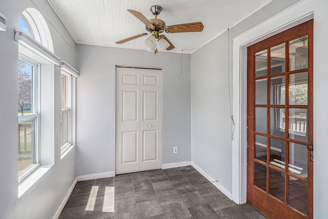 unfurnished bedroom with baseboards, stone finish floors, a closet, and ceiling fan