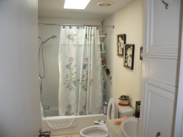 full bath with toilet, visible vents, vanity, and shower / bath combination with curtain