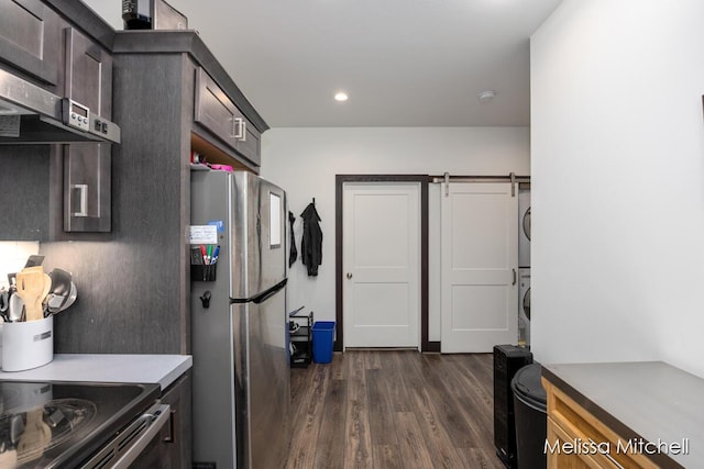 506 Fairview Ave NE, Grand Rapids, MI 49503 - kitchen featuring freestanding refrigerator, a barn door, stacked washer and dryer, recessed lighting, and dark wood-style flooring