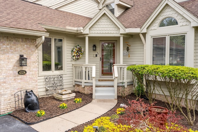 entrance to property featuring roof with shingles