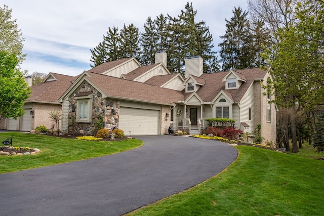 view of front of home with asphalt driveway, an attached garage, a chimney, a front yard, and stone siding