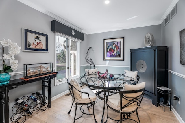 dining area with wood finished floors, crown molding, and baseboards