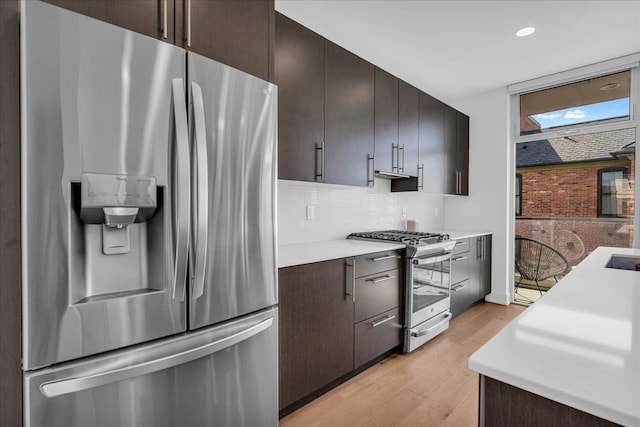 2809 Brush St, Detroit, MI 48201 - kitchen featuring light wood-style flooring, light countertops, appliances with stainless steel finishes, decorative backsplash, and recessed lighting