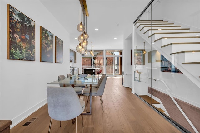 2809 Brush St, Detroit, MI 48201 - dining space with hardwood / wood-style floors, visible vents, baseboards, and stairway