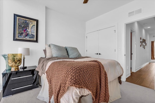 2809 Brush St, Detroit, MI 48201 - carpeted bedroom with wood finished floors, a closet, visible vents, baseboards, and ceiling fan