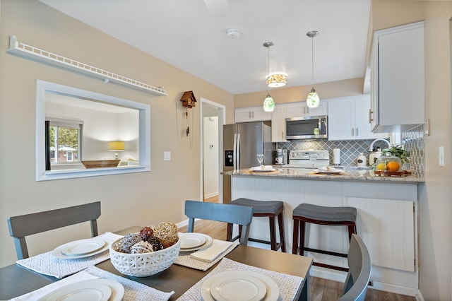 dining area featuring wood finished floors and baseboards
