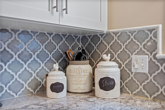 interior details with light stone countertops and white cabinets
