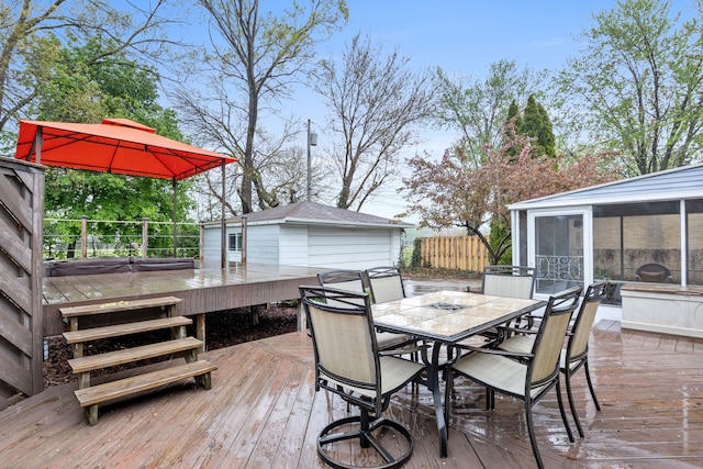 wooden terrace with outdoor dining area, a sunroom, and fence