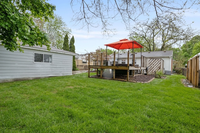 view of yard with a deck, an outdoor structure, a gazebo, and fence