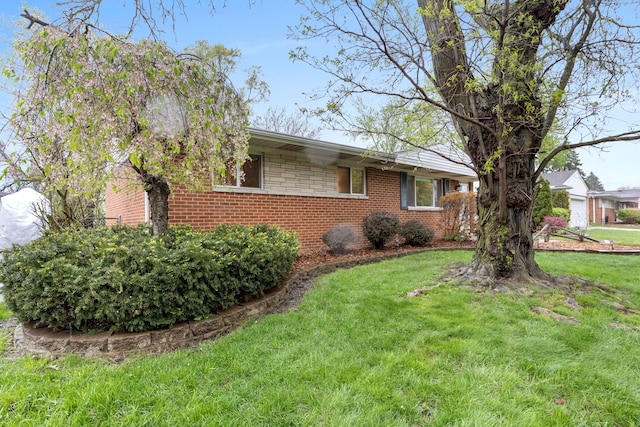 view of home's exterior featuring a yard and brick siding