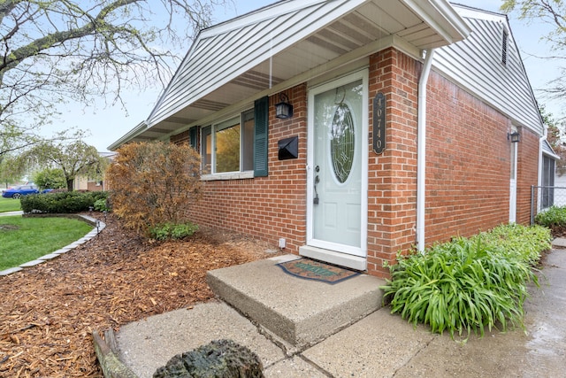 entrance to property featuring brick siding