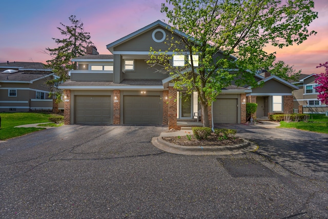 traditional-style house with driveway, brick siding, and a garage