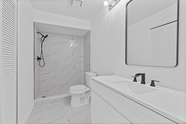 bathroom with a closet, toilet, marble finish floor, vanity, and a marble finish shower