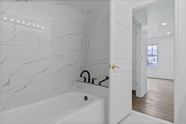 bathroom with recessed lighting and a bathing tub