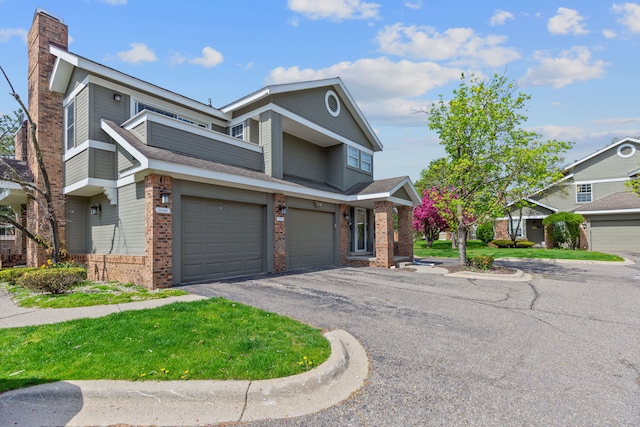 multi unit property featuring a chimney, brick siding, a garage, and aphalt driveway
