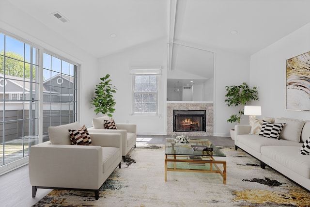 living room featuring a premium fireplace, wood finished floors, visible vents, and vaulted ceiling with beams