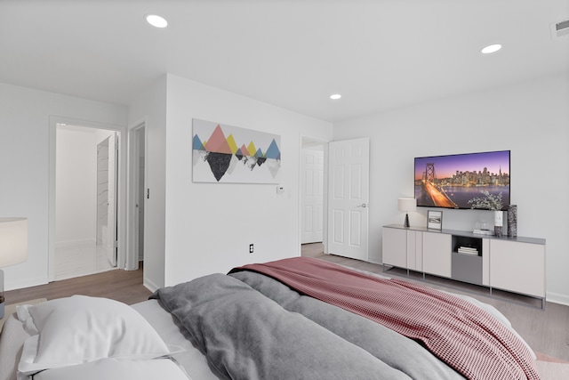 bedroom featuring baseboards, recessed lighting, visible vents, and wood finished floors