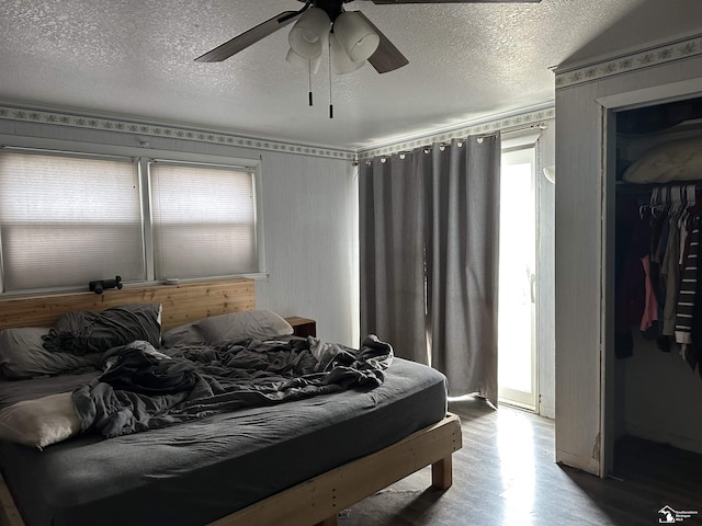 bedroom featuring a textured ceiling, wood finished floors, and ceiling fan