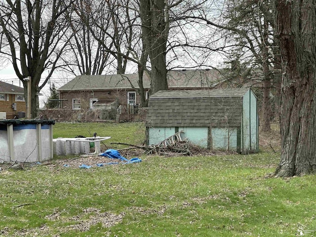 view of yard featuring a swimming pool, an outbuilding, and a storage shed