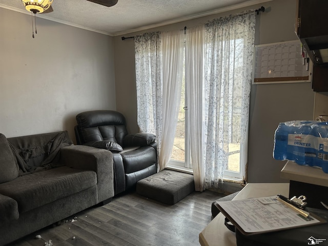 living area with crown molding, a textured ceiling, a ceiling fan, and wood finished floors